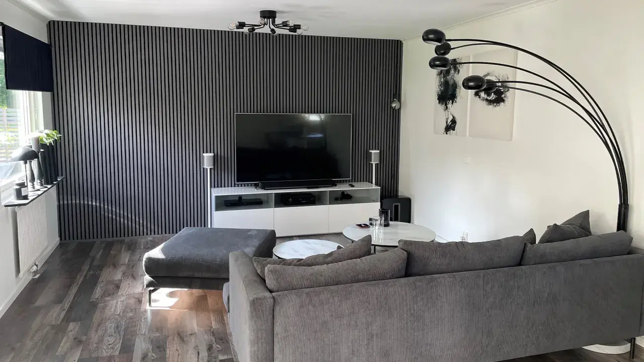 Modernt tvrum med ribbvägg och grå soffa. Perfekt tvrum inspiration för dig som gillar stilrent och avskalat.