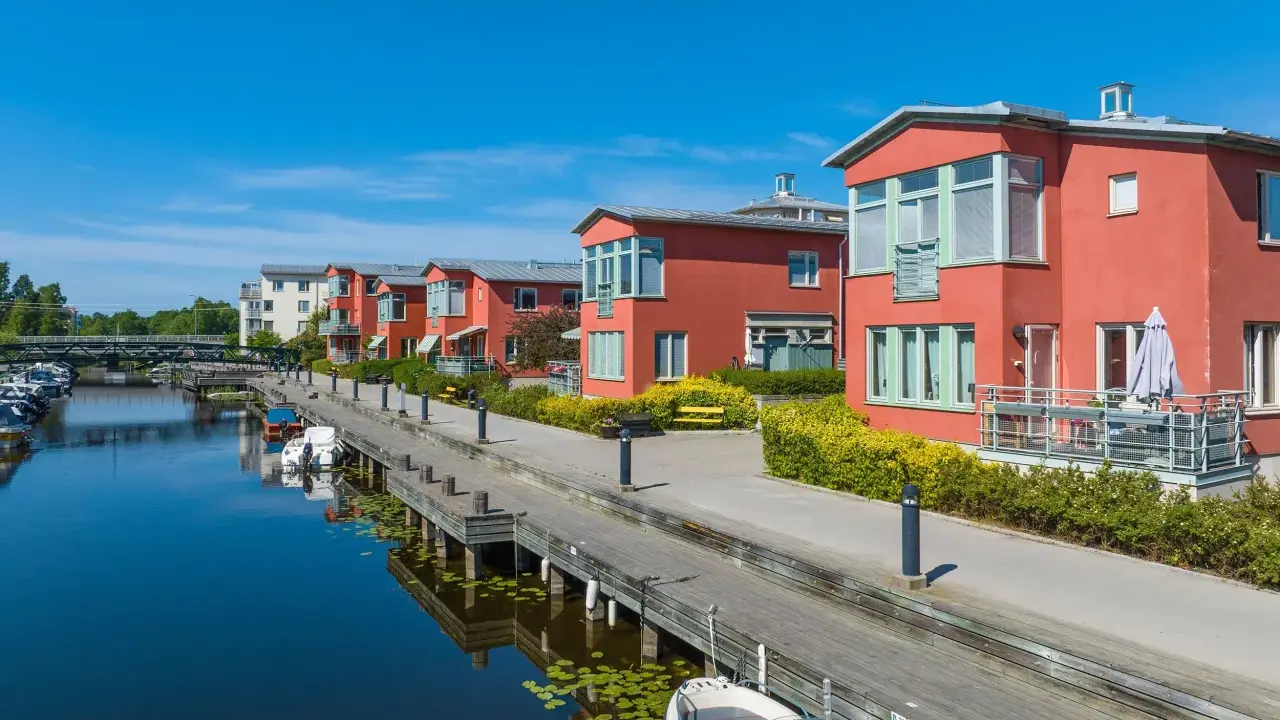 Radhus vid vattnet med båtar i hamnen. En extern styrelse för brf kan diskutera kostnad för underhåll av bryggan.