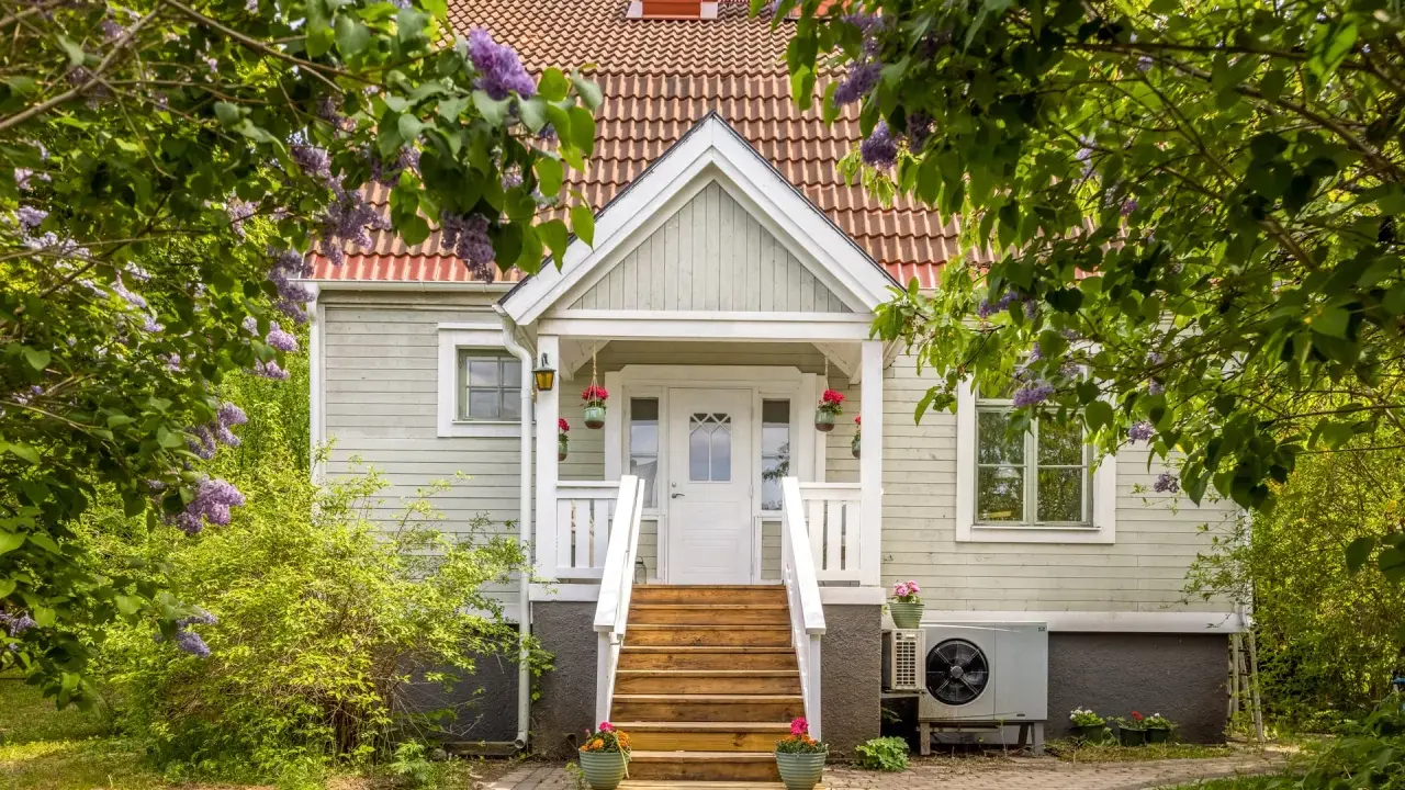 Vackert hus med syrenbuskar i blom. Tänk vad skönt med skattereduktion för fastighetsavgift när man bor så här fint.