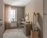 Mysigt hemmakontor med skrivbord, stol, lampa och tygrullar. Perfekt hemmakontor inspiration för kreativa själar.