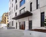 Modern villa med stenfasad och dubbeldörrar. En skylt visar "VILLA SCHELLENBURG". Kanske en symbol för en brf konkurs?