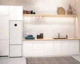 Vit tvättstuga med Bosch Compress 7800i värmepump, tvättmaskin, torktumlare och en bänkskiva med diskho.