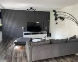 Modernt tvrum med ribbvägg och grå soffa. Perfekt tvrum inspiration för dig som gillar stilrent och avskalat.