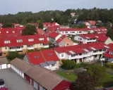 Radhusområde med röda tak i Sverige. Tänk på att fastighetsskatt för brf kan påverka boendekostnaderna.