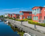 Radhus vid vattnet med båtar i hamnen. En extern styrelse för brf kan diskutera kostnad för underhåll av bryggan.