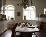 Rustik matplats med träbord, röda stolar och en bänk. Vackra fönster och skåp ger inspiration för inredningstips.