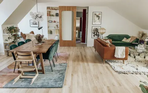 Ett vardagsrum med matplats och soffgrupp. Flera mattor i samma rum skapar en ombonad känsla.