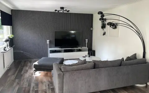 Modernt tvrum med ribbvägg och grå soffa. Perfekt tvrum inspiration för dig som gillar stilrent och avskalat.