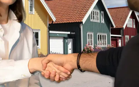 Handslag framför färgglada hus. Kanske en affär som gör det möjligt att **låna till handpenning** för drömhuset.