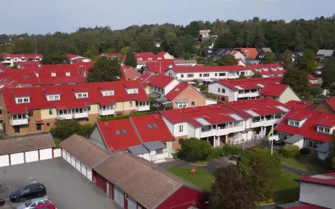Radhusområde med röda tak i Sverige. Tänk på att fastighetsskatt för brf kan påverka boendekostnaderna.