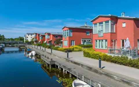 Radhus vid vattnet med båtar i hamnen. En extern styrelse för brf kan diskutera kostnad för underhåll av bryggan.