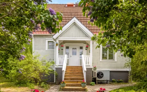 Vackert hus med syrenbuskar i blom. Tänk vad skönt med skattereduktion för fastighetsavgift när man bor så här fint.
