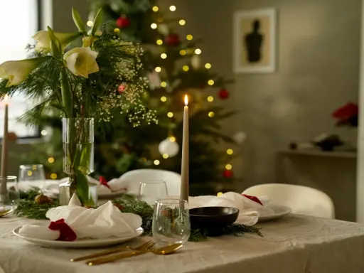 Vacker julpynt inspiration med dukat bord, amaryllis och julgran i bakgrunden. Ljusen skapar en mysig stämning.