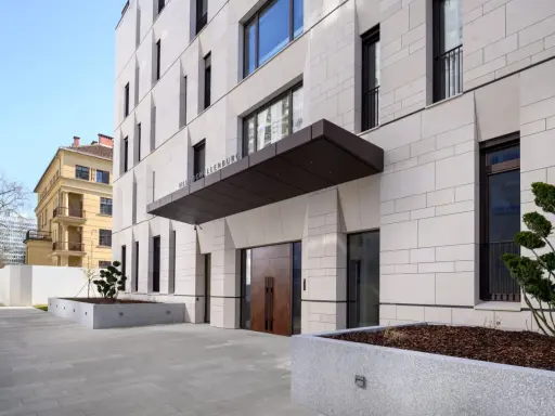 Modern villa med stenfasad och dubbeldörrar. En skylt visar "VILLA SCHELLENBURG". Kanske en symbol för en brf konkurs?