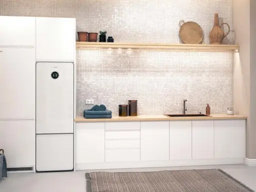 Vit tvättstuga med Bosch Compress 7800i värmepump, tvättmaskin, torktumlare och en bänkskiva med diskho.