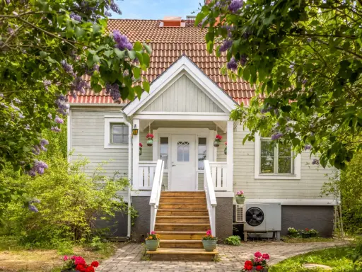 Vackert hus med syrenbuskar i blom. Tänk vad skönt med skattereduktion för fastighetsavgift när man bor så här fint.
