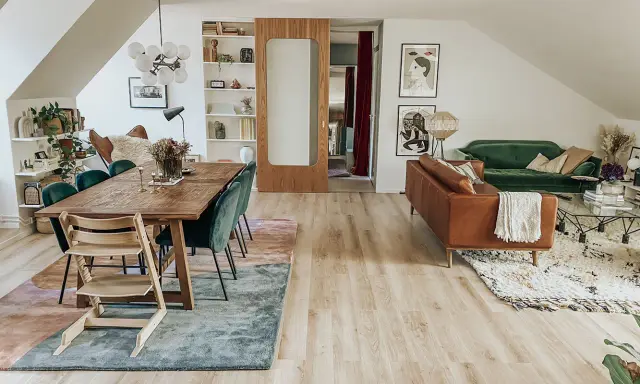 Ett vardagsrum med matplats och soffgrupp. Flera mattor i samma rum skapar en ombonad känsla.