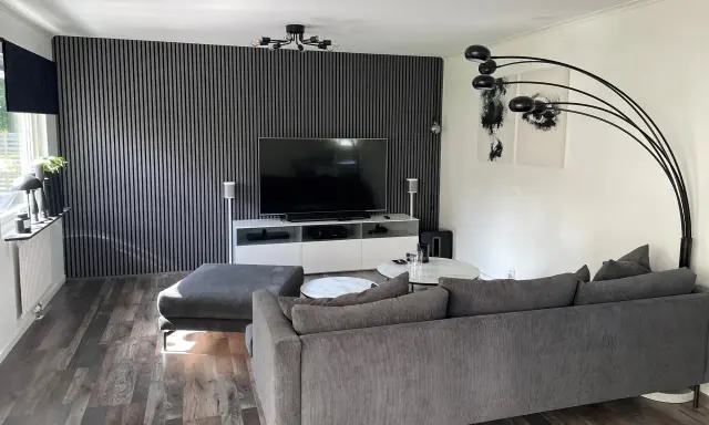 Modernt tvrum med ribbvägg och grå soffa. Perfekt tvrum inspiration för dig som gillar stilrent och avskalat.