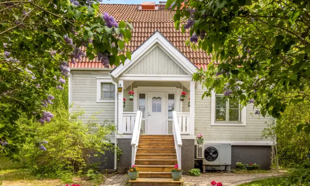 Vackert hus med syrenbuskar i blom. Tänk vad skönt med skattereduktion för fastighetsavgift när man bor så här fint.