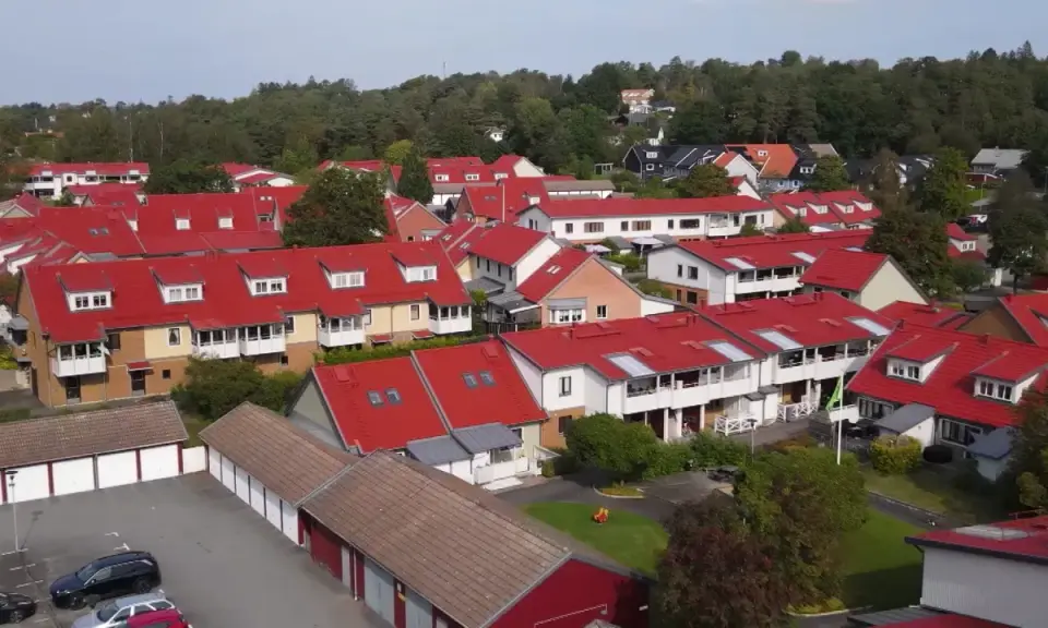 Radhusområde med röda tak i Sverige. Tänk på att fastighetsskatt för brf kan påverka boendekostnaderna.