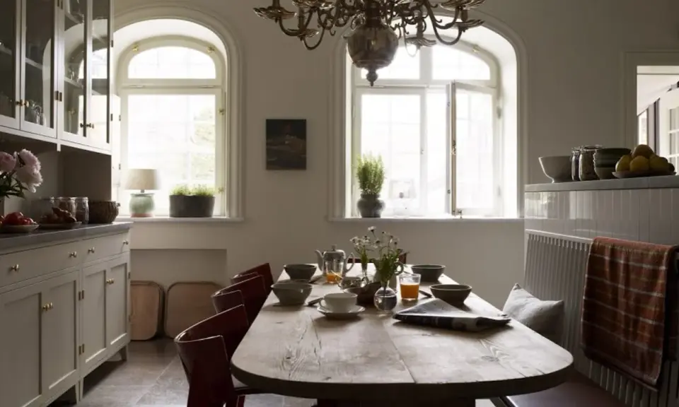 Rustik matplats med träbord, röda stolar och en bänk. Vackra fönster och skåp ger inspiration för inredningstips.