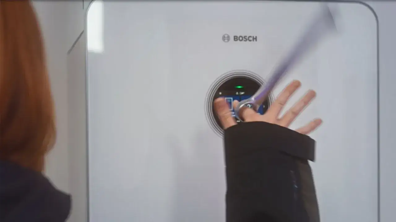 En hand interagerar med displayen p&aring; en Bosch Compress 7800i v&auml;rmepump.