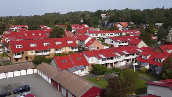 Radhusområde med röda tak i Sverige. Tänk på att fastighetsskatt för brf kan påverka boendekostnaderna.